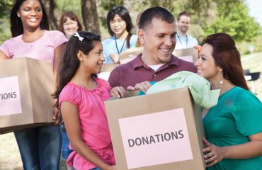 Happy family holding donations box at a donation center.